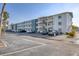 A condo complex showing the exterior elevation including car parking and tropical landscaping at 5891 Welcome Rd # I6, Bradenton, FL 34207
