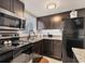 Well-lit kitchen featuring dark cabinets, stainless steel appliances, and granite countertops at 5891 Welcome Rd # I6, Bradenton, FL 34207