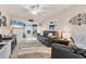 Bright living room with leather furniture, ceiling fan, and sliding glass doors to a patio at 5891 Welcome Rd # I6, Bradenton, FL 34207