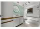 Well-lit bathroom boasts a vanity, round mirror and a bathtub with shower at 6061 Fairway Ln # 1411, Bradenton, FL 34210