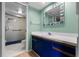 Bright bathroom features a vanity with blue cabinets and a tiled shower with glass doors at 6061 Fairway Ln # 1411, Bradenton, FL 34210