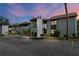 Condominium building featuring a parking area and tropical landscaping at 6061 Fairway Ln # 1411, Bradenton, FL 34210