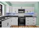 Modern kitchen with white cabinets, stainless steel appliances, and sleek backsplash at 6061 Fairway Ln # 1411, Bradenton, FL 34210