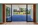 Enclosed lanai featuring blue flooring and a tranquil view of the well-maintained backyard at 6061 Fairway Ln # 1411, Bradenton, FL 34210