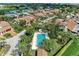 Aerial view of a pool area with lounge chairs, surrounded by mature trees and manicured landscaping at 6111 Courtside Dr # 61, Bradenton, FL 34210