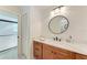 Bathroom featuring wood cabinets, marble countertop, round mirror and a shower at 6111 Courtside Dr # 61, Bradenton, FL 34210