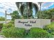 Entrance sign for the Racquet Club Villas with lush green landscaping at 6111 Courtside Dr # 61, Bradenton, FL 34210