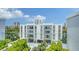 A modern, four-story condo building showcases balconies, covered parking and lush landscaping at 626 Rawls Ave # 626, Sarasota, FL 34236