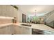 Kitchen with stainless steel sink, white cabinetry, and open access to the dining and living area at 626 Rawls Ave # 626, Sarasota, FL 34236