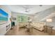 Spacious living area boasts neutral tones, wood-look flooring, and stairs with steel railings, and dual matching couches at 626 Rawls Ave # 626, Sarasota, FL 34236