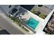 Aerial view of a community pool, surrounded by lounge seating, palm trees, and a sleek, modern building at 626 Rawls Ave # 626, Sarasota, FL 34236