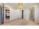 Bedroom with modern light fixture, dark doors, and view to hallway, closet, and bathroom at 670 Old Compass Rd, Longboat Key, FL 34228