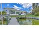 Waterfront property featuring a private dock extending from a well-manicured lawn, offering direct water access at 670 Old Compass Rd, Longboat Key, FL 34228