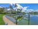 Canal view of a private boat dock with boat lift and lush landscaping near waterfront home at 670 Old Compass Rd, Longboat Key, FL 34228