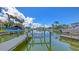 Scenic waterfront home featuring a private dock and boat lift on a beautiful canal with palm trees at 670 Old Compass Rd, Longboat Key, FL 34228