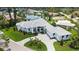 Stunning aerial view of a pristine modern home with lush landscaping and a circular driveway at 670 Old Compass Rd, Longboat Key, FL 34228