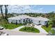 Striking home features a circular driveway, three-car garage, lush landscaping, and well-manicured lawn at 670 Old Compass Rd, Longboat Key, FL 34228