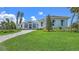 Gorgeous home boasting lush lawn, beautiful landscaping, and inviting front entry with decorative sidelight windows at 670 Old Compass Rd, Longboat Key, FL 34228