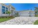 A beautiful home with manicured landscaping and a paver driveway leading to a three-car garage provides curb appeal at 670 Old Compass Rd, Longboat Key, FL 34228