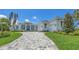 Stately home with a multi-car garage, paver driveway, lush landscaping, and decorative windows provides curb appeal at 670 Old Compass Rd, Longboat Key, FL 34228