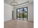 Living room with light hardwood flooring and large sliding doors that bring the tropical outdoors inside at 670 Old Compass Rd, Longboat Key, FL 34228