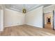 Bright living room with wood floors, recessed lights, tray ceiling, and modern light fixture at 670 Old Compass Rd, Longboat Key, FL 34228