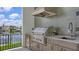 The covered outdoor kitchen has stainless appliances, granite countertops and a view of the water at 670 Old Compass Rd, Longboat Key, FL 34228