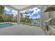 Covered patio boasts an outdoor kitchen, railing and overlooks a serene waterfront and lush tropical foliage at 670 Old Compass Rd, Longboat Key, FL 34228