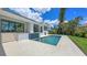 Backyard with a beautiful pool and patio with elegant sliding glass doors and a lush landscaped garden at 670 Old Compass Rd, Longboat Key, FL 34228