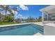 Backyard pool with patio, waterfront view, private dock, and lush tropical landscaping at 670 Old Compass Rd, Longboat Key, FL 34228