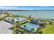 Aerial view of community pool, playground, tennis, and pickle ball courts overlooking a lake at 7352 Cabin Ln, Sarasota, FL 34240