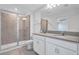 Modern bathroom featuring dual sinks, gray countertops, and glass-enclosed shower at 7352 Cabin Ln, Sarasota, FL 34240