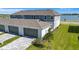 View of the rear of the property showing a two car garage and a well maintained lawn at 7352 Cabin Ln, Sarasota, FL 34240