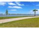 Picturesque lake view with a walking path surrounded by a lush green landscape at 7352 Cabin Ln, Sarasota, FL 34240