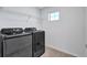 Modern laundry room featuring a front load washer and dryer and a wire shelf above at 7352 Cabin Ln, Sarasota, FL 34240