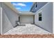 A wide open patio with paver flooring features two lounge chairs and an exterior door at 7352 Cabin Ln, Sarasota, FL 34240