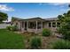 Rear view of the home featuring a covered patio and a beautifully landscaped yard at 7404 14Th W Ave, Bradenton, FL 34209