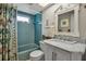 This bathroom has a blue tiled shower, a modern vanity with a marble countertop, and decorative accents, creating a stylish and functional space at 7404 14Th W Ave, Bradenton, FL 34209