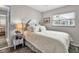 This bedroom has neutral walls and white bedding, a side table with decor, and a sunny window for a peaceful ambiance at 7404 14Th W Ave, Bradenton, FL 34209