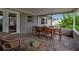 Cozy covered patio featuring brick flooring and charming wicker seating area at 7404 14Th W Ave, Bradenton, FL 34209