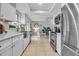 Bright kitchen with stainless steel appliances and white cabinets overlooks the living area at 7404 14Th W Ave, Bradenton, FL 34209
