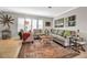 Well-lit living room with a comfortable sectional sofa, decorative rug, and stylish window shutters at 7404 14Th W Ave, Bradenton, FL 34209
