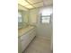 Bright bathroom with double sinks, a window, and plenty of storage space at 753 Tropical Cir, Sarasota, FL 34242