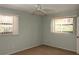 This is a vacant bedroom with two windows, a ceiling fan, and neutral-colored walls and carpet at 753 Tropical Cir, Sarasota, FL 34242