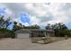 The exterior of a single-story home with an attached garage, paved driveway, and a neatly maintained front yard at 753 Tropical Cir, Sarasota, FL 34242