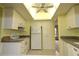 Functional kitchen with white appliances, ample cabinet space, and a tiled floor at 753 Tropical Cir, Sarasota, FL 34242
