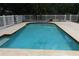 An inviting pool with light blue water is surrounded by a white fence, providing a secure and picturesque space at 753 Tropical Cir, Sarasota, FL 34242