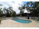 Backyard pool surrounded by white fencing, lush foliage, and a screen porch on the rear of the house at 753 Tropical Cir, Sarasota, FL 34242