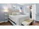 Tranquil bedroom with blue walls, hardwood floors, a decorative headboard, and access to the screened-in porch at 7747 33Rd E St, Sarasota, FL 34243