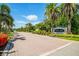 Community entrance featuring lush landscaping, a brick-paved road, and a 'Palm Lakes' sign at 7747 33Rd E St, Sarasota, FL 34243